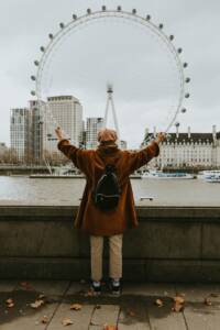 a person posing across the London Eye.