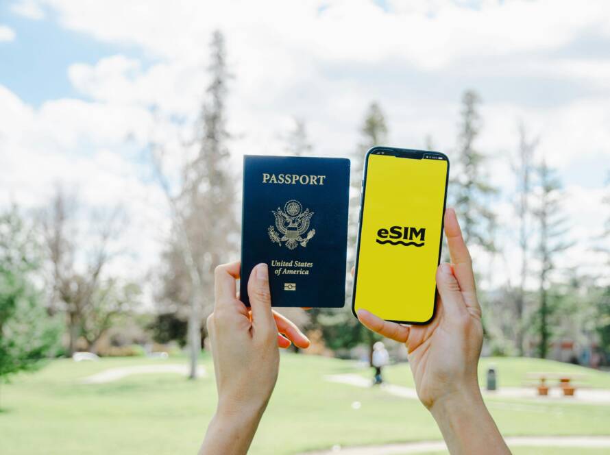 two hands holding a passport in one hand and a phone in the other.